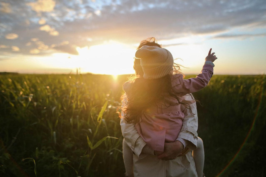 parent carrying daughter outdoors